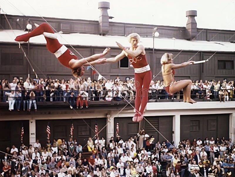 Trapeze performers execute a breathtaking, perilous maneuver as a spellbound crowd looks on.  The circus daredevils precision routine was part of the entertainment at the Navy Pier during the first ChicagoFest in August, 1978. Trapeze performers execute a breathtaking, perilous maneuver as a spellbound crowd looks on.  The circus daredevils precision routine was part of the entertainment at the Navy Pier during the first ChicagoFest in August, 1978.