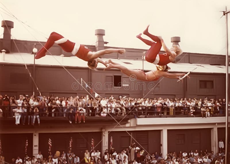 Trapeze performers execute a breathtaking, perilous maneuver as a spellbound crowd looks on.  The circus daredevils precision routine was part of the entertainment at the Navy Pier during the first ChicagoFest in August, 1978. Trapeze performers execute a breathtaking, perilous maneuver as a spellbound crowd looks on.  The circus daredevils precision routine was part of the entertainment at the Navy Pier during the first ChicagoFest in August, 1978.