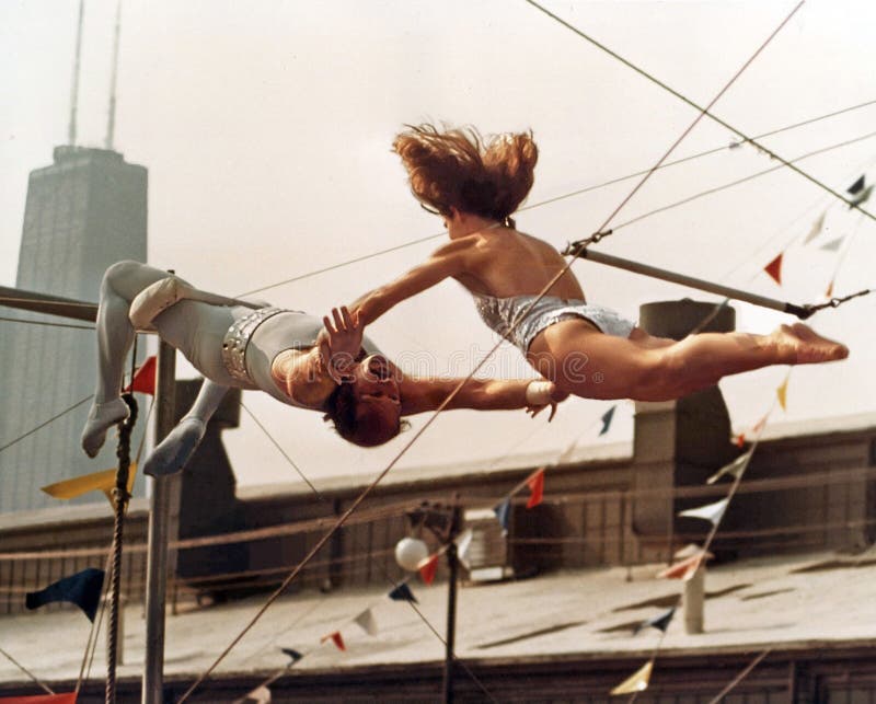 Trapeze performers execute a breathtaking, perilous maneuver.  The circus daredevils precision routine was part of the entertainment at the Navy Pier during the first ChicagoFest in August, 1978. The action takes place in the shadow of the 100 story, 1,128-foot skyscraper, the John Hancock Center, now Chicago`s 4th highest building. Trapeze performers execute a breathtaking, perilous maneuver.  The circus daredevils precision routine was part of the entertainment at the Navy Pier during the first ChicagoFest in August, 1978. The action takes place in the shadow of the 100 story, 1,128-foot skyscraper, the John Hancock Center, now Chicago`s 4th highest building.