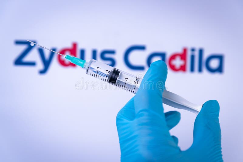 In this photo illustration a hand in medical gloves hold a syringe in front of Zydus Cadila logo in Barcelona, Spain on September 2, 2021. Zydus Cadila is an indian company developing the Covid-19 vaccine CNBC-TV18, also know as ZyCoV D. In this photo illustration a hand in medical gloves hold a syringe in front of Zydus Cadila logo in Barcelona, Spain on September 2, 2021. Zydus Cadila is an indian company developing the Covid-19 vaccine CNBC-TV18, also know as ZyCoV D