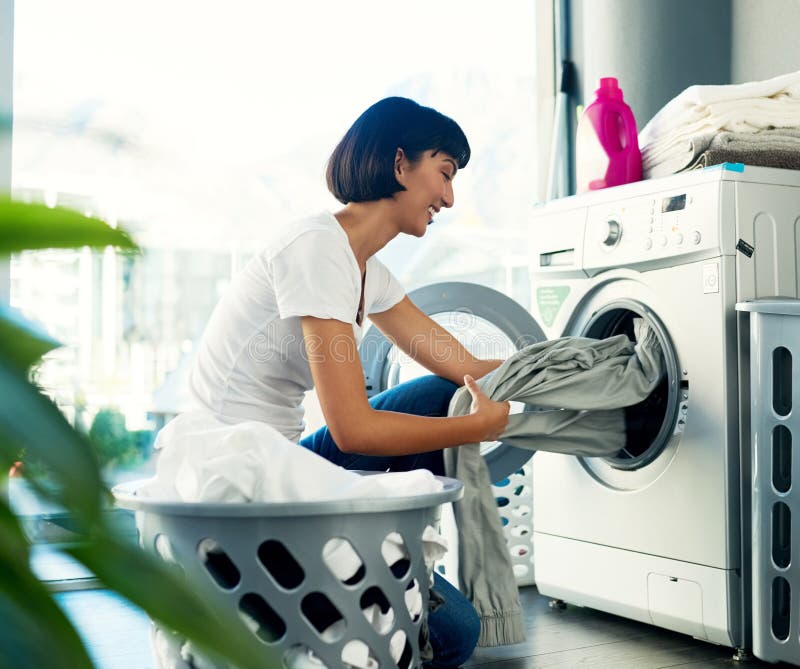 I Enjoy Doing My Own Laundry Shot Of A Young Woman Doing Her Laundry At Home Stock Image