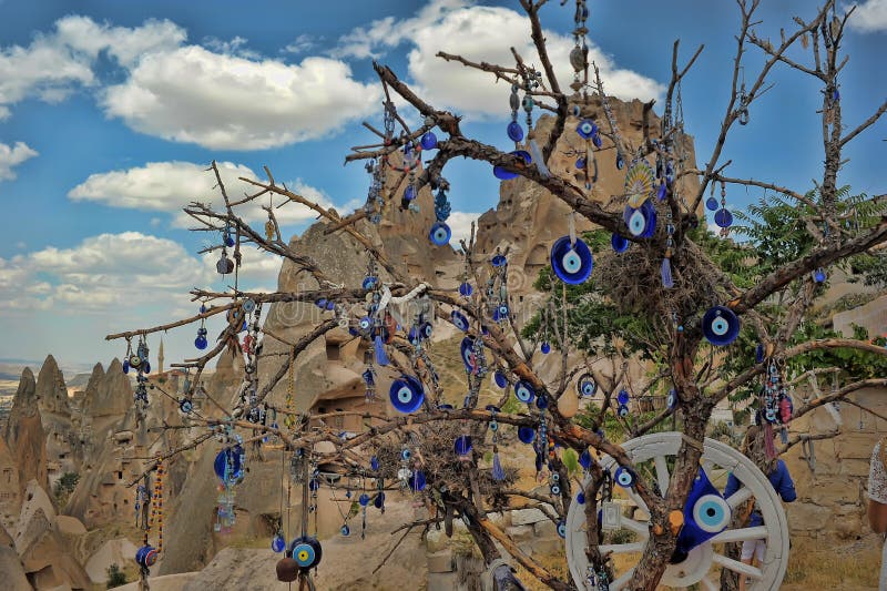 I fascini dell'occhio diabolico pendono da un albero nudo in Cappadoci fotografia stock I fascini dell'occhio diabolico pendono da un albero nudo in Cappadoci fotografia stock