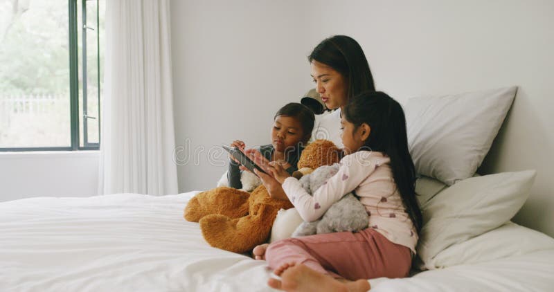 I genitori si collegano con due ragazzi felici mentre navigano su internet per giocare ai giochi divertenti e imparare dalle app p stock footage