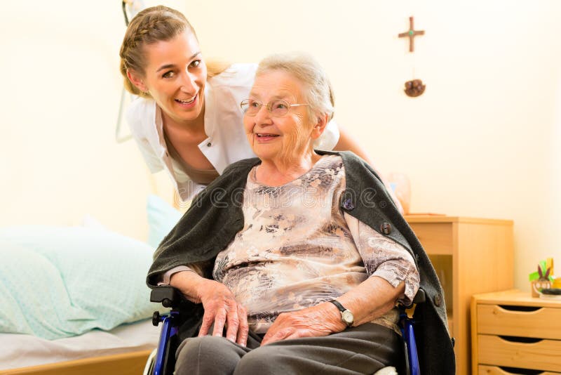 Young nurse and female senior in nursing home, the old lady sitting in a wheel chair. Young nurse and female senior in nursing home, the old lady sitting in a wheel chair