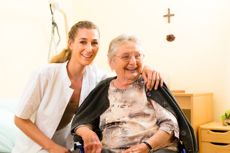 Young nurse and female senior in nursing home, the old lady sitting in a wheel chair. Young nurse and female senior in nursing home, the old lady sitting in a wheel chair