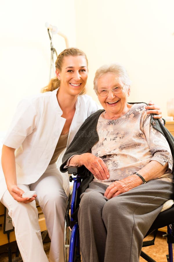 Young nurse and female senior in nursing home, the old lady sitting in a wheel chair. Young nurse and female senior in nursing home, the old lady sitting in a wheel chair