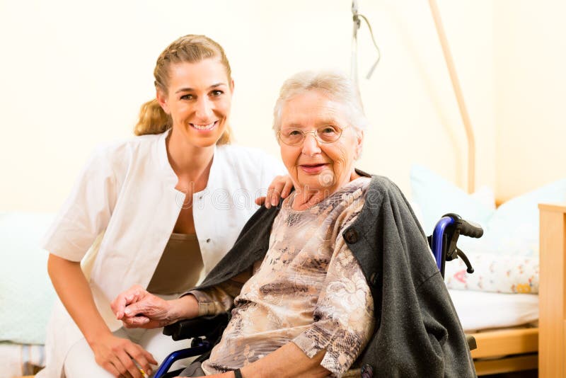 Young nurse and female senior in nursing home, the old lady sitting in a wheel chair. Young nurse and female senior in nursing home, the old lady sitting in a wheel chair