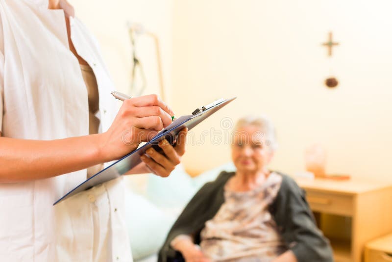 Young nurse and female senior in nursing home, measurements are taken or administrative duties taken care of. Young nurse and female senior in nursing home, measurements are taken or administrative duties taken care of