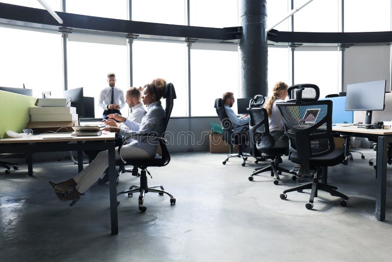 I giovani d'affari che lavorano in ufficio usano la tecnologia moderna immagine stock I giovani d'affari che lavorano in ufficio usano la tecnologia moderna immagine stock