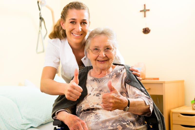 Young nurse and female senior in nursing home, the old lady sitting in a wheel chair. Young nurse and female senior in nursing home, the old lady sitting in a wheel chair