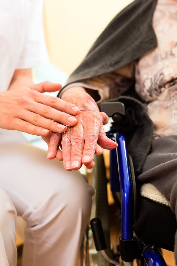 Young nurse and female senior in nursing home, the old lady sitting in a wheel chair. Young nurse and female senior in nursing home, the old lady sitting in a wheel chair