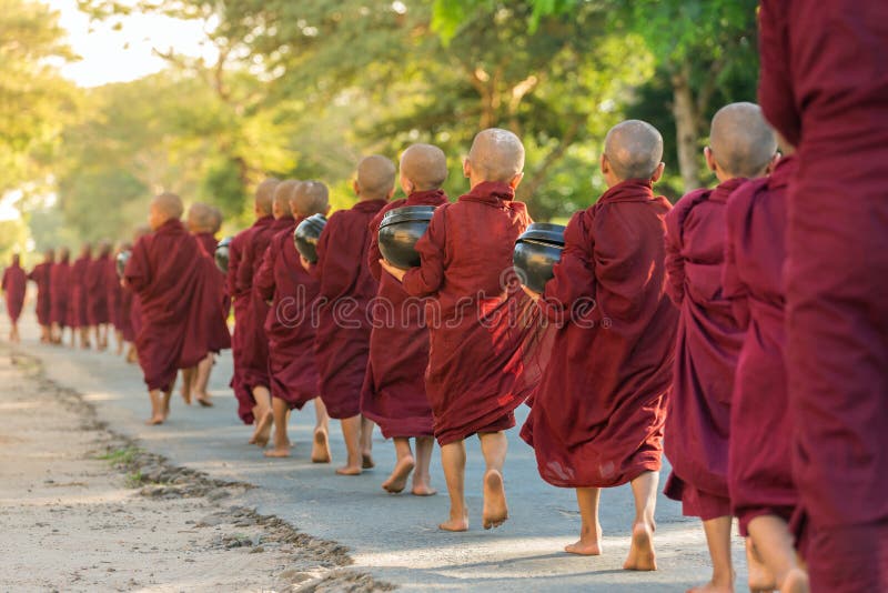 I giovani principianti buddisti camminano per raccogliere le elemosine e le offerti sulle vie di Bagan, Myanmar fotografia stock libera da diritti I giovani principianti buddisti camminano per raccogliere le elemosine e le offerti sulle vie di Bagan, Myanmar fotografia stock libera da diritti