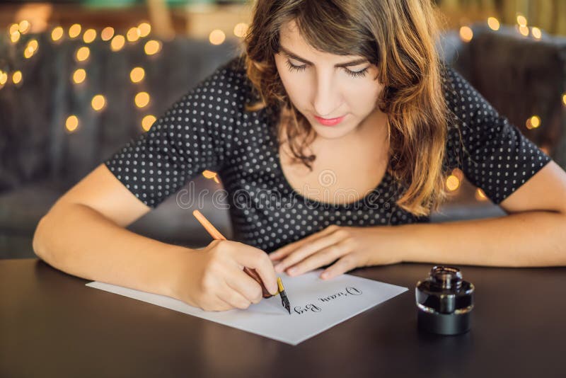 I grandi scopi di sogno dell'insieme agiscono Il calligrafo Young Woman scrive la frase su Libro Bianco Iscrivendo ornamentale de immagini stock I grandi scopi di sogno dell'insieme agiscono Il calligrafo Young Woman scrive la frase su Libro Bianco Iscrivendo ornamentale de immagini stock