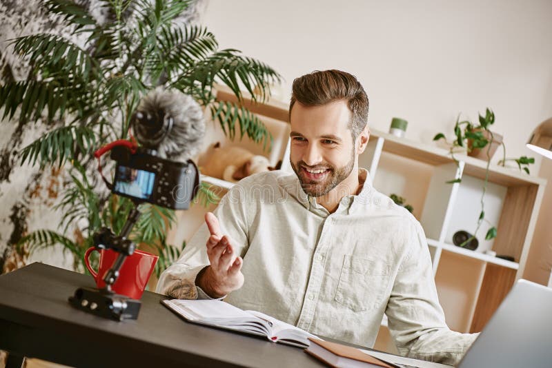 I am so happy! Cheerful young male blogger making a new content for his vlog with tripod mounted digital camera. royalty free stock image I am so happy! Cheerful young male blogger making a new content for his vlog with tripod mounted digital camera. royalty free stock image