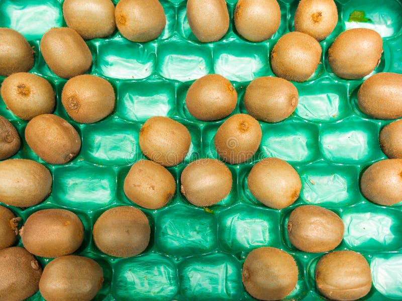 I kiwi si inverdiscono la scatola di plastica in supermercato come fondo dell'alimento. Vendita al dettaglio. fotografie stock libere da diritti I kiwi si inverdiscono la scatola di plastica in supermercato come fondo dell'alimento. Vendita al dettaglio. fotografie stock libere da diritti