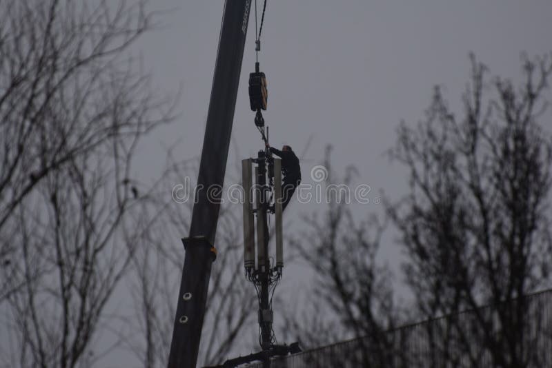 On the roof of a vacant 14-storey office building  the mobile telephone transmission mast will be removed. A heavy  high crane is used and the workers look like real daredevils. On the roof of a vacant 14-storey office building  the mobile telephone transmission mast will be removed. A heavy  high crane is used and the workers look like real daredevils.