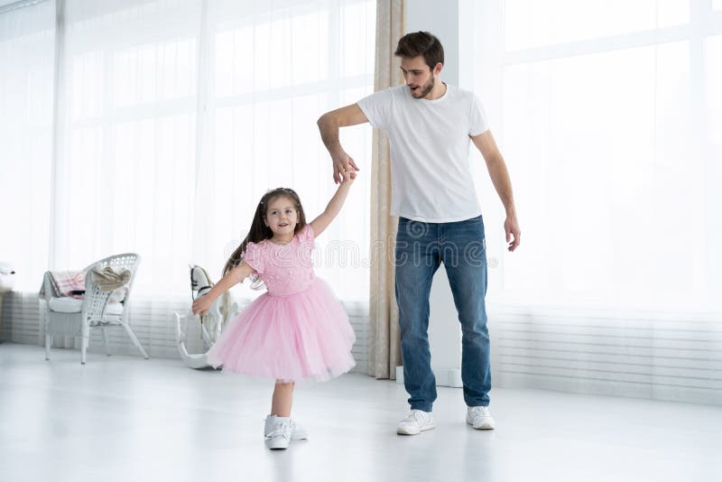 I love you, dad! Handsome young man is dancing at home with his little girl. Happy Father`s Day! stock photos I love you, dad! Handsome young man is dancing at home with his little girl. Happy Father`s Day! stock photos