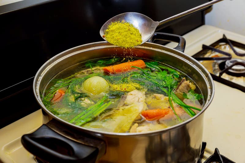 Chicken Broth with Pieces of Vegetables in a Metal Pot before Cooking