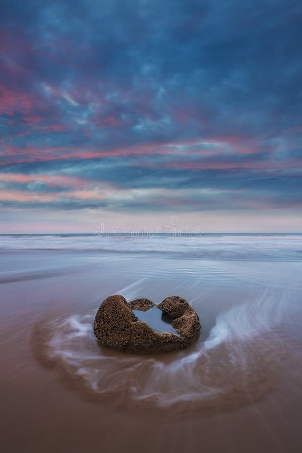 I massi di Moeraki sul Koekohe tirano, costa orientale della Nuova Zelanda Tramonto ed esposizione lunga e un cielo drammatico di fotografia stock libera da diritti I massi di Moeraki sul Koekohe tirano, costa orientale della Nuova Zelanda Tramonto ed esposizione lunga e un cielo drammatico di fotografia stock libera da diritti