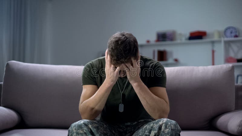 I militari maschi nervosi soffrono di depressione, seduti soli a casa, concetto di PTSD