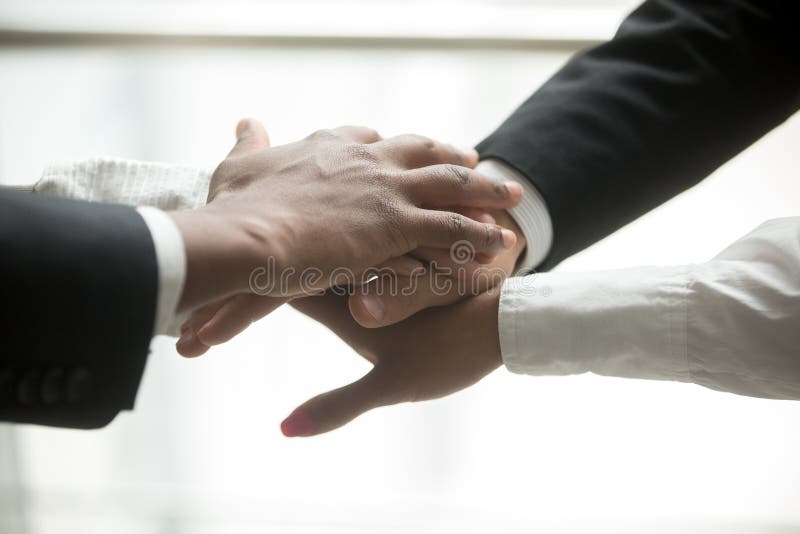 I partner africani e caucasici hanno un le mani, vicino sulla vista fotografia stock libera da diritti I partner africani e caucasici hanno un le mani, vicino sulla vista fotografia stock libera da diritti