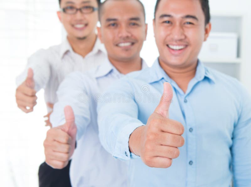 I pollici aumentano gli uomini d'affari asiatici sudorientali immagini stock libere da diritti I pollici aumentano gli uomini d'affari asiatici sudorientali immagini stock libere da diritti