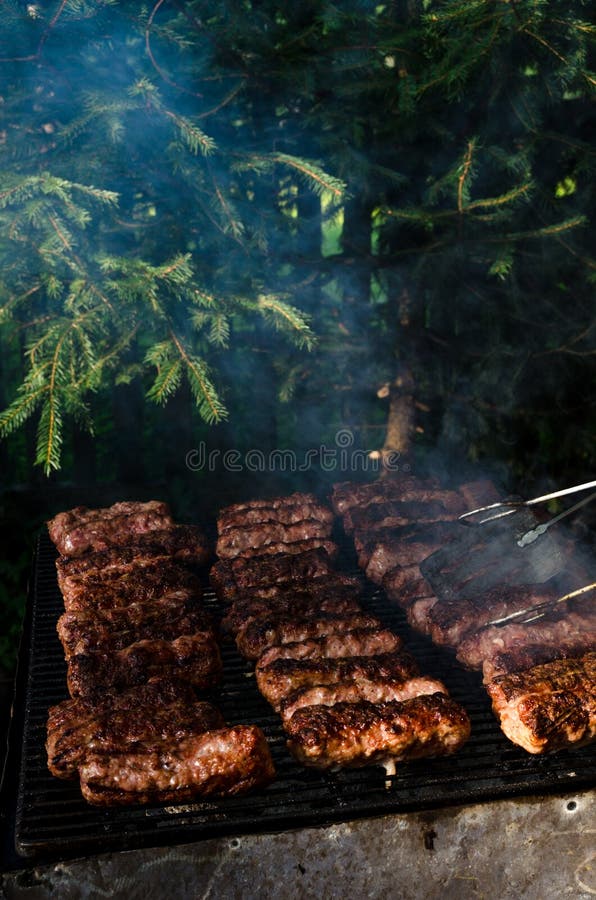I polpettoni tritati arrostiti hanno chiamato Mici o Mititei in cucina rumena tradizionale cucinata fuori un giorno di estate sul fotografia stock libera da diritti I polpettoni tritati arrostiti hanno chiamato Mici o Mititei in cucina rumena tradizionale cucinata fuori un giorno di estate sul fotografia stock libera da diritti