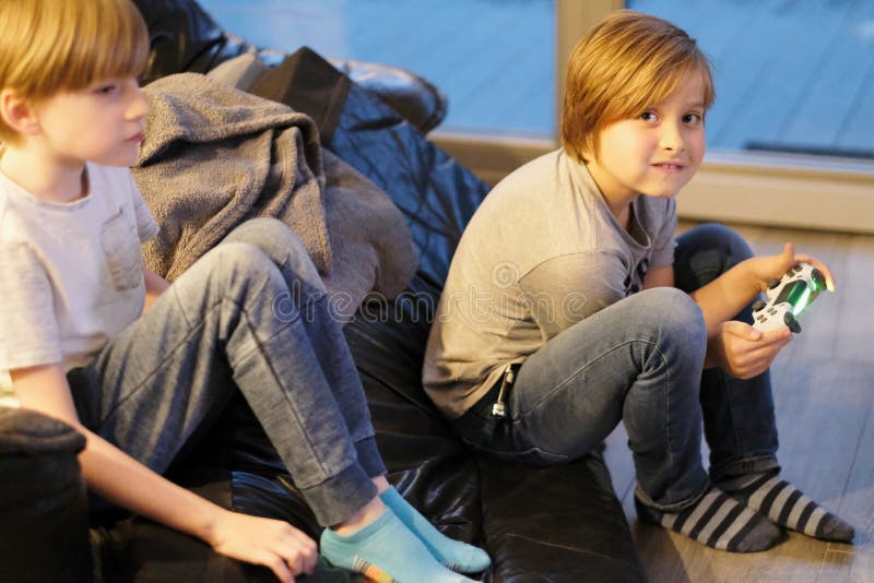 I ragazzi di scuola giocano sul pavimento in una casa fotografie stock libere da diritti I ragazzi di scuola giocano sul pavimento in una casa fotografie stock libere da diritti