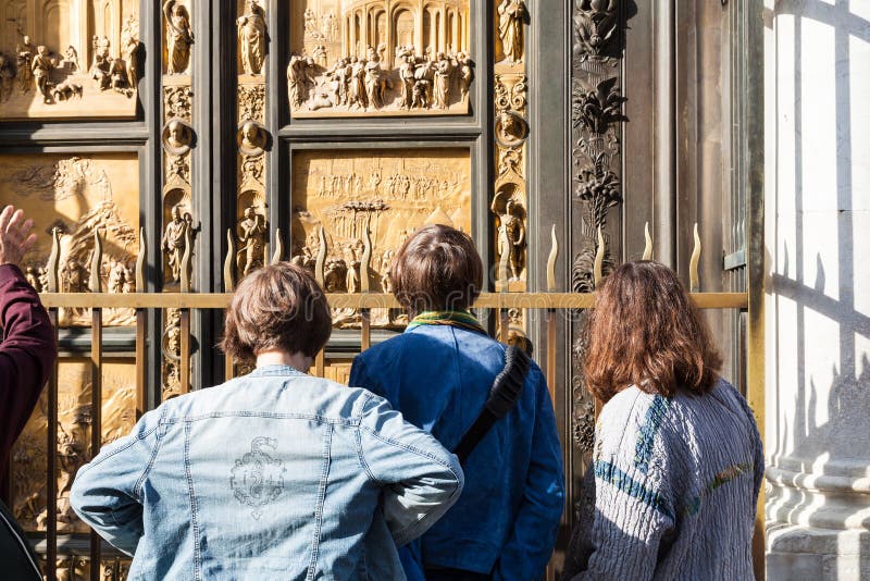 I turisti considerano le porte orientali del battistero immagine stock libera da diritti I turisti considerano le porte orientali del battistero immagine stock libera da diritti