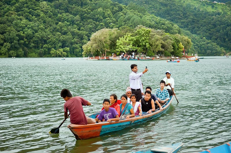 I turisti godono del giro nel vasto lago Phewa, colori naturali della barca immagini stock I turisti godono del giro nel vasto lago Phewa, colori naturali della barca immagini stock