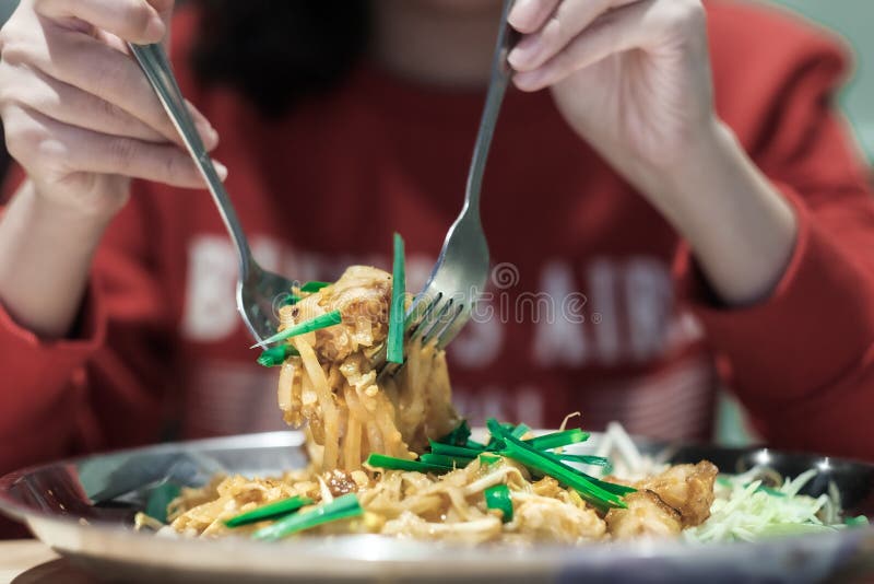 I turisti mangiano Pad Thai in un ristorante thailandese immagine stock libera da diritti I turisti mangiano Pad Thai in un ristorante thailandese immagine stock libera da diritti