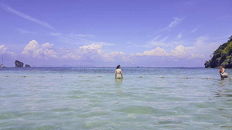 I turisti prendono la ragazza delle foto in un mare di chiari cieli al krabi in Thiland immagine stock libera da diritti I turisti prendono la ragazza delle foto in un mare di chiari cieli al krabi in Thiland immagine stock libera da diritti