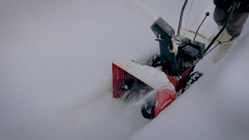 I vinter A gör mannen ren vägen från snö efter maskin för snöfallsnöborttagning