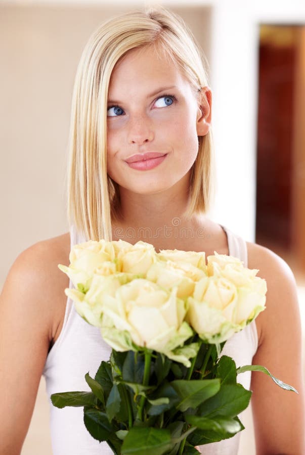 I wonder if hes waiting outside. A young woman holding a bunch of roses.