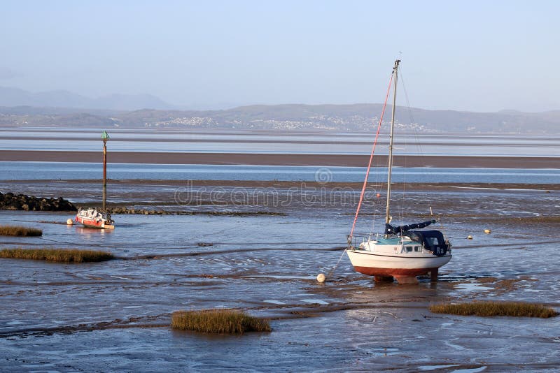 Iate e o outro bote na costa pelo passeio de Morecambe no lado da baía de Morecambe, Lancashire, Inglaterra com wiew através do fotos de stock royalty free Iate e o outro bote na costa pelo passeio de Morecambe no lado da baía de Morecambe, Lancashire, Inglaterra com wiew através do fotos de stock royalty free