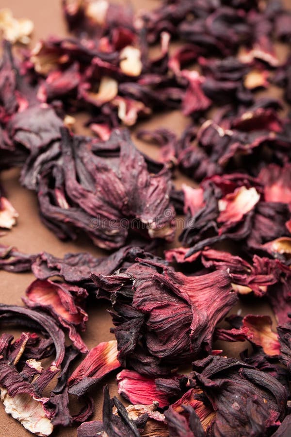 Ibisco secco dei petali del fiore su una tavola marrone d'annata fotografia stock Ibisco secco dei petali del fiore su una tavola marrone d'annata fotografia stock