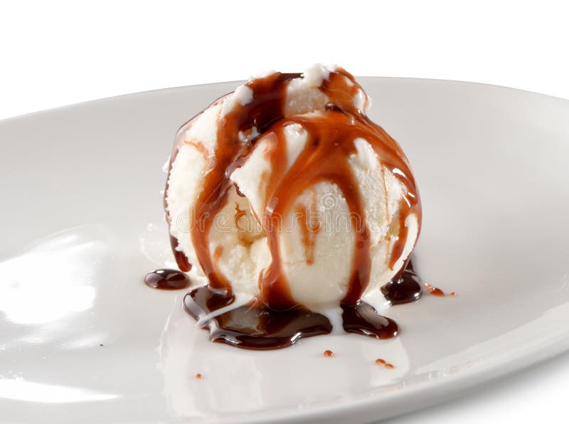 Ice cream scoop topped with chocolate sauce on plate close-up isolated on white background