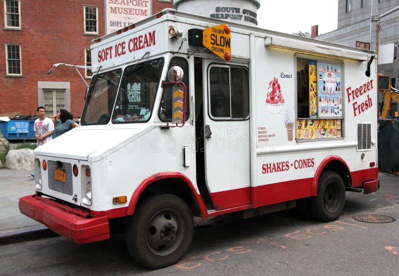 Ice cream truck on the side of a city street.