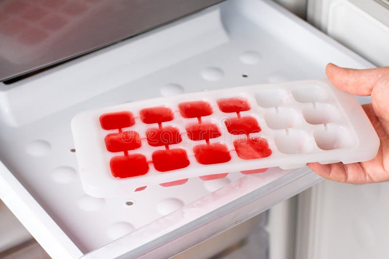 A Woman Opens An Ice Maker Tray In The Freezer To Take Ice Cubes To Cool  Drinks. Stock Photo, Picture and Royalty Free Image. Image 147627293.