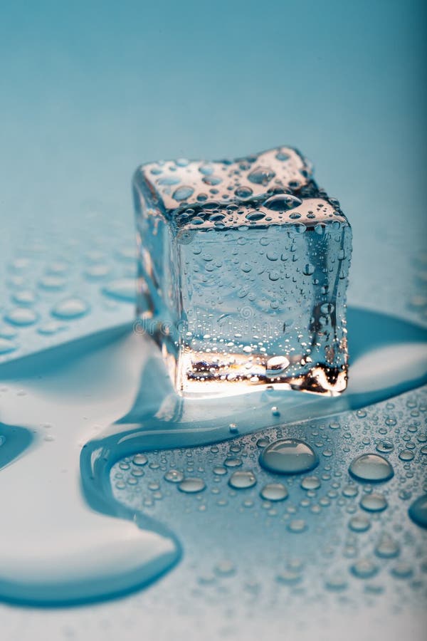 Ice Cube with Water Drops on a Blue Background. the Ice is Melting