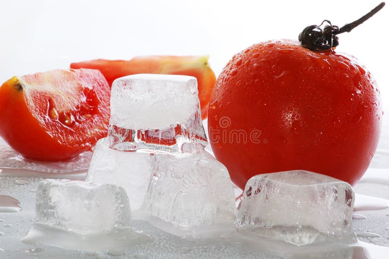 Fünf Eiswürfel geschmolzen in Wasser und Tomaten.