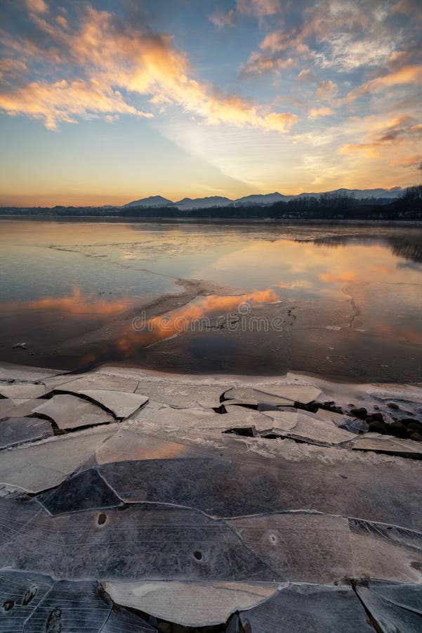 Ice floes on the lake shore. Colorful sky during sunrise on cold winter morning.Dam Liptovska Mara, Slovakia