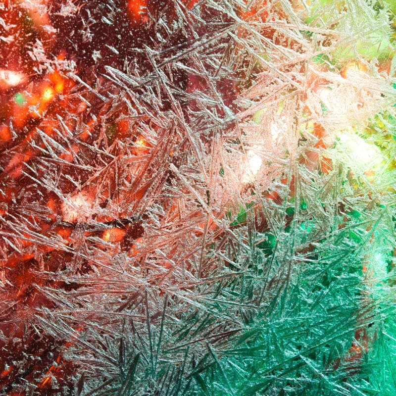 Ice flowers. Frost flowers. Frozen window. Winter in the window. Christmas lights in the window. Illumination. stock photo Ice flowers. Frost flowers. Frozen window. Winter in the window. Christmas lights in the window. Illumination. stock photo