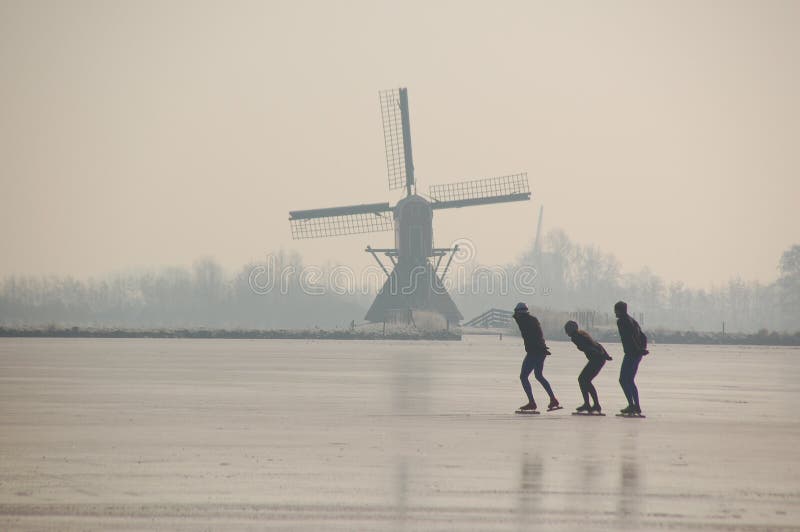 Ice-skaters in front of a Windmill Winter in Holland