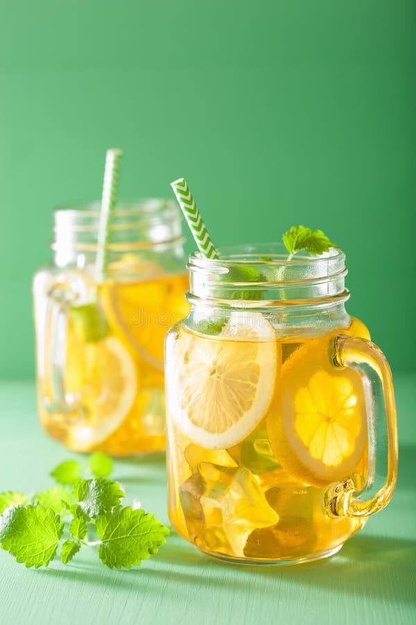 Ice tea with lemon and melissa in mason jars