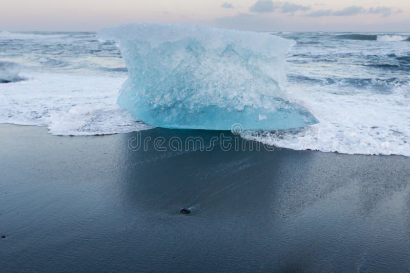 Iceberg en la playa negra de la arena sobre la playa del diamante de Jokulsarlon foto de archivo libre de regalías Iceberg en la playa negra de la arena sobre la playa del diamante de Jokulsarlon foto de archivo libre de regalías