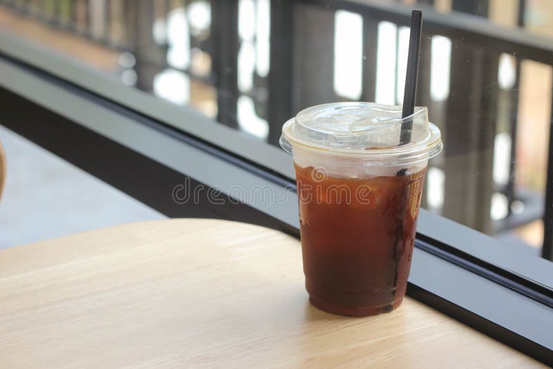 https://thumbs.dreamstime.com/b/iced-black-tasty-coffee-plastic-cup-straw-wooden-table-coffee-shop-iced-black-tasty-coffee-beverage-plastic-cup-239019626.jpg