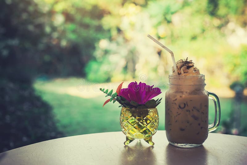 Iced Coffee and Flower Vase on the Table Style Vintage Stock Photo