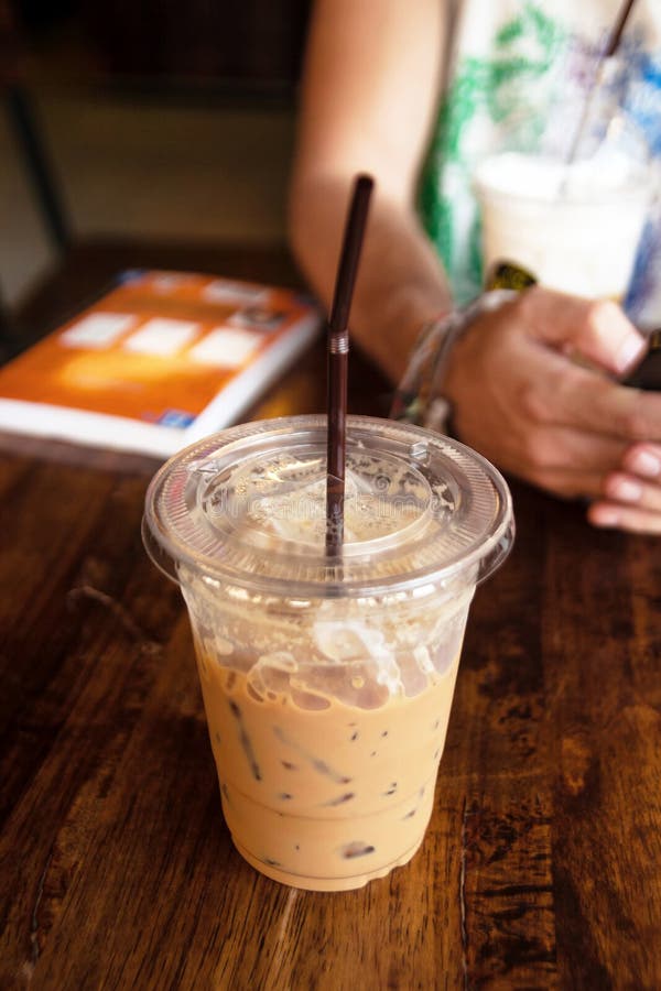 https://thumbs.dreamstime.com/b/iced-coffee-plastic-cup-straw-wooden-table-cafe-iced-coffee-plastic-cup-straw-wooden-table-107155541.jpg