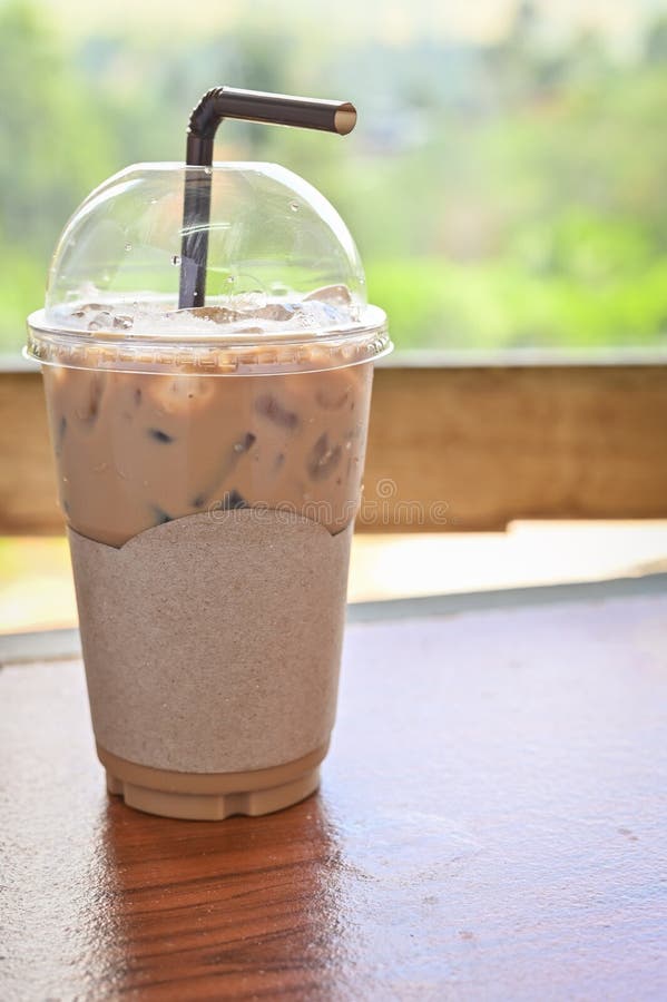 Iced coffee or latte in take away plastic cup on cafe table. Disposable  transparent plastic coffee cup. Coffee and milc coffee cocktail Stock Photo